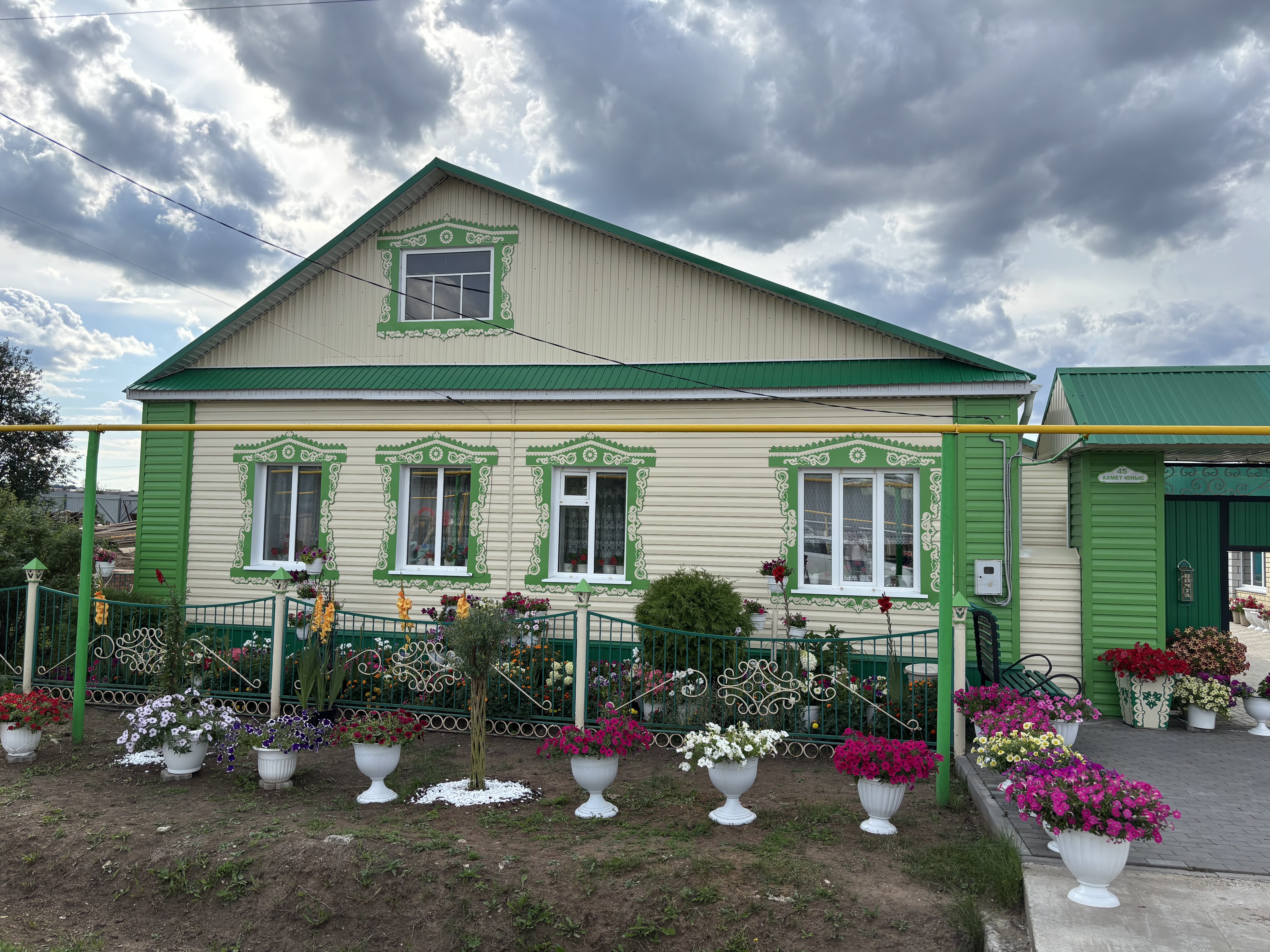 Билаловлар гаиләсенең йорт яны чәчәкләргә күмелгән.